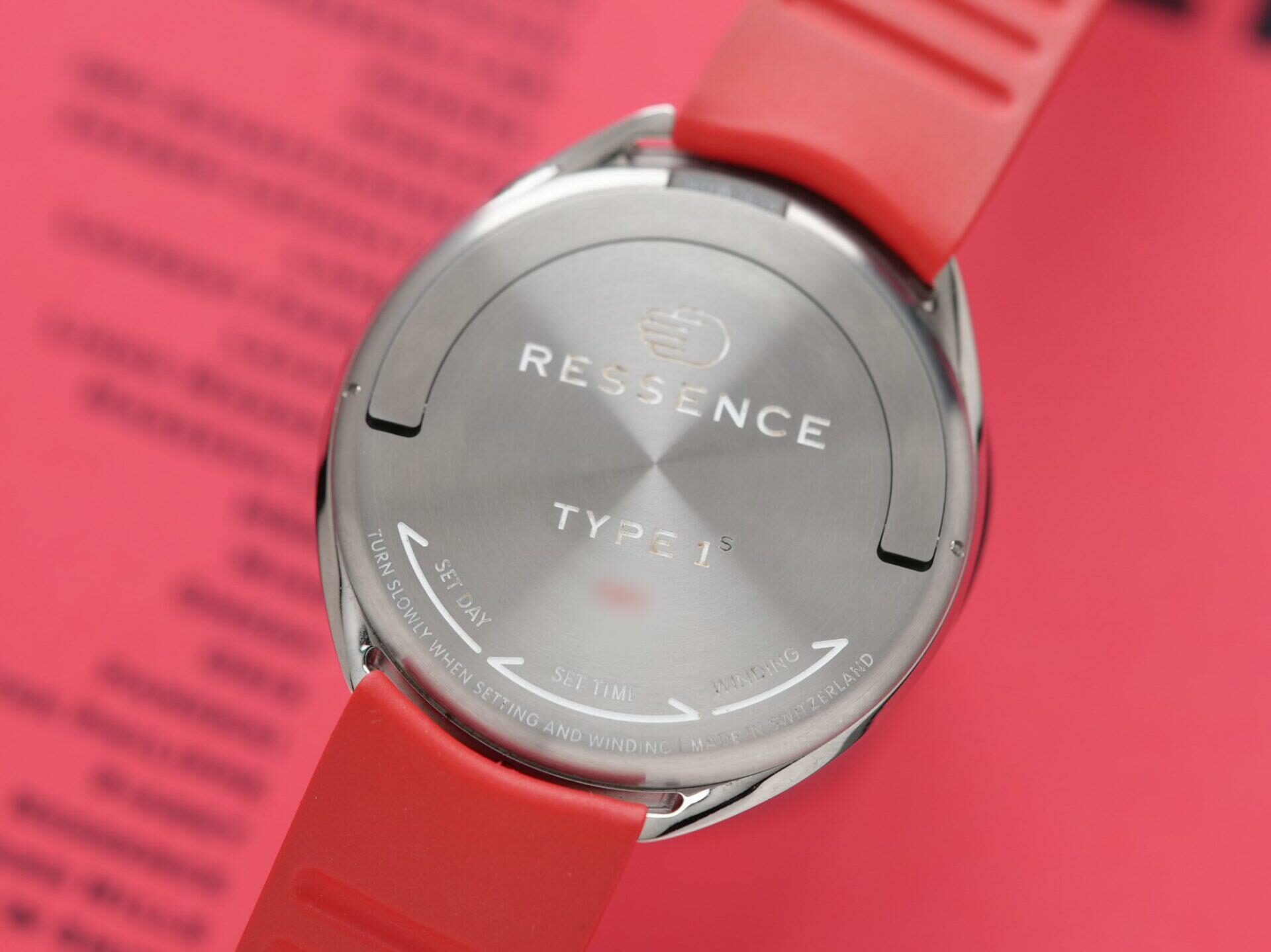 The back side of the Ressence Type 1 Slim Red being displayed closeup with red background.