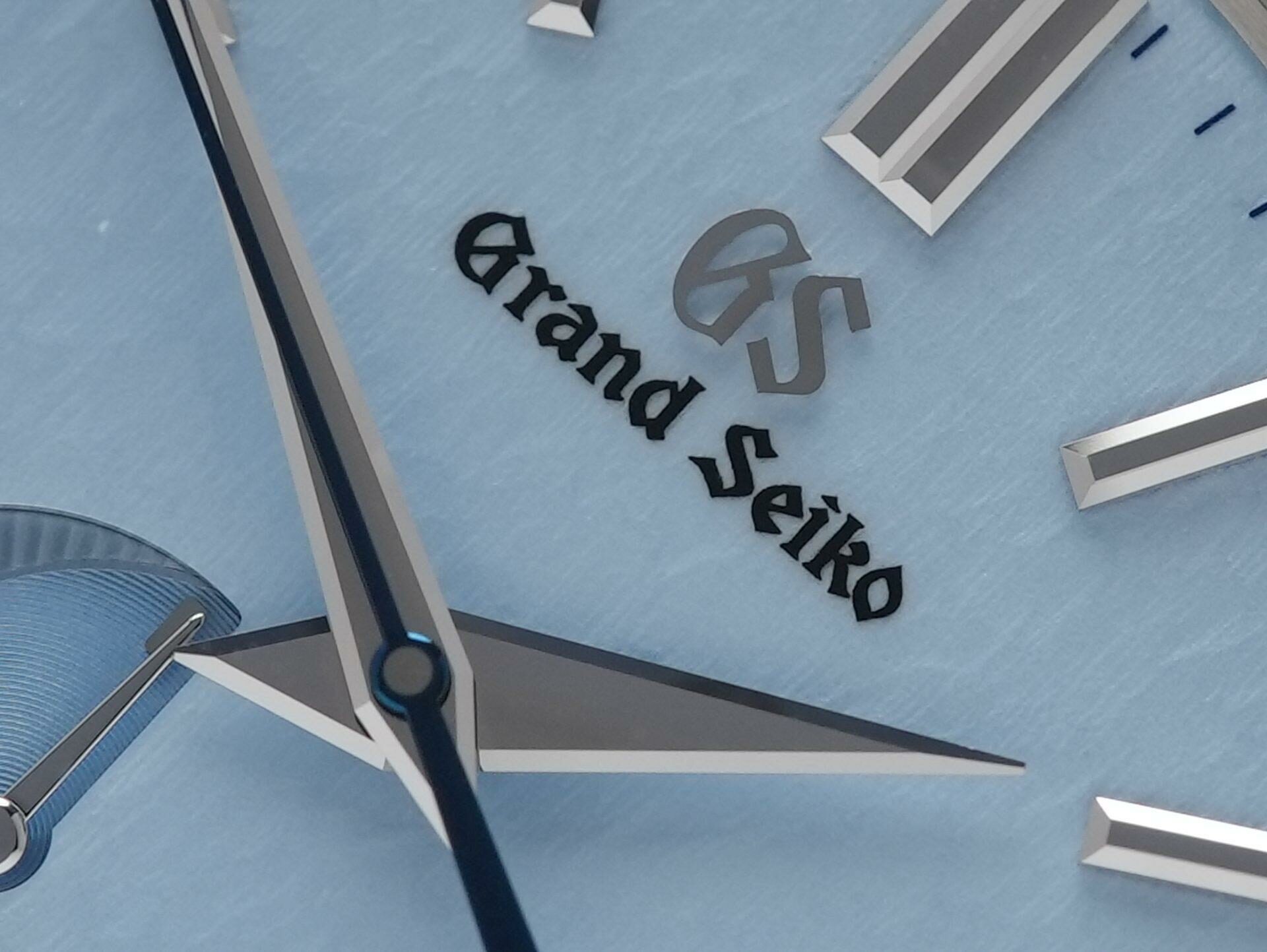 Grand Seiko SBGA407 SkyFlake on display showing the blue “Snowflake” dial zoomed in and closeup of Grand Seiko logo.