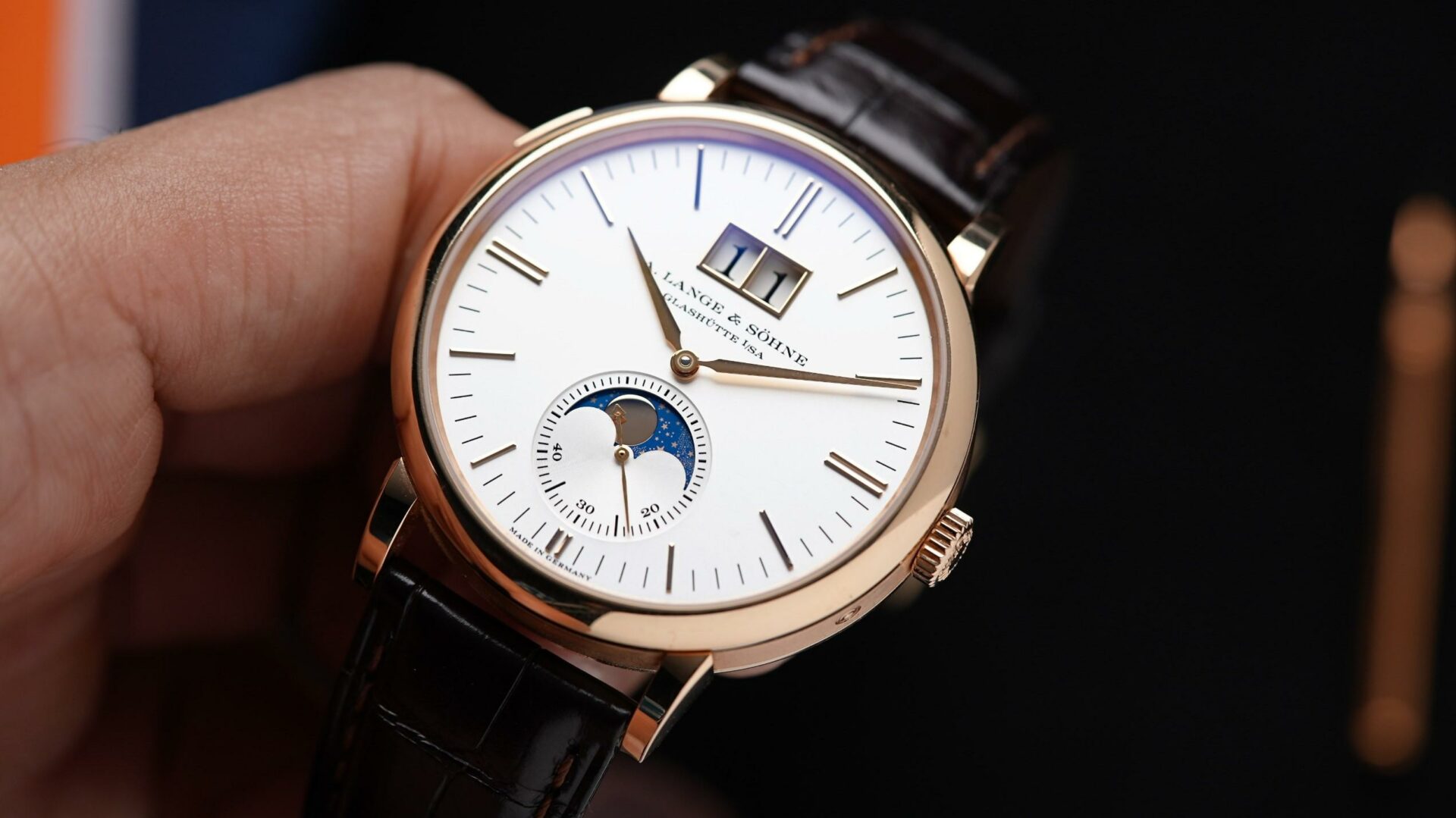 A. Lange & Söhne Saxonia Moon Phase Rose Gold held in hand.