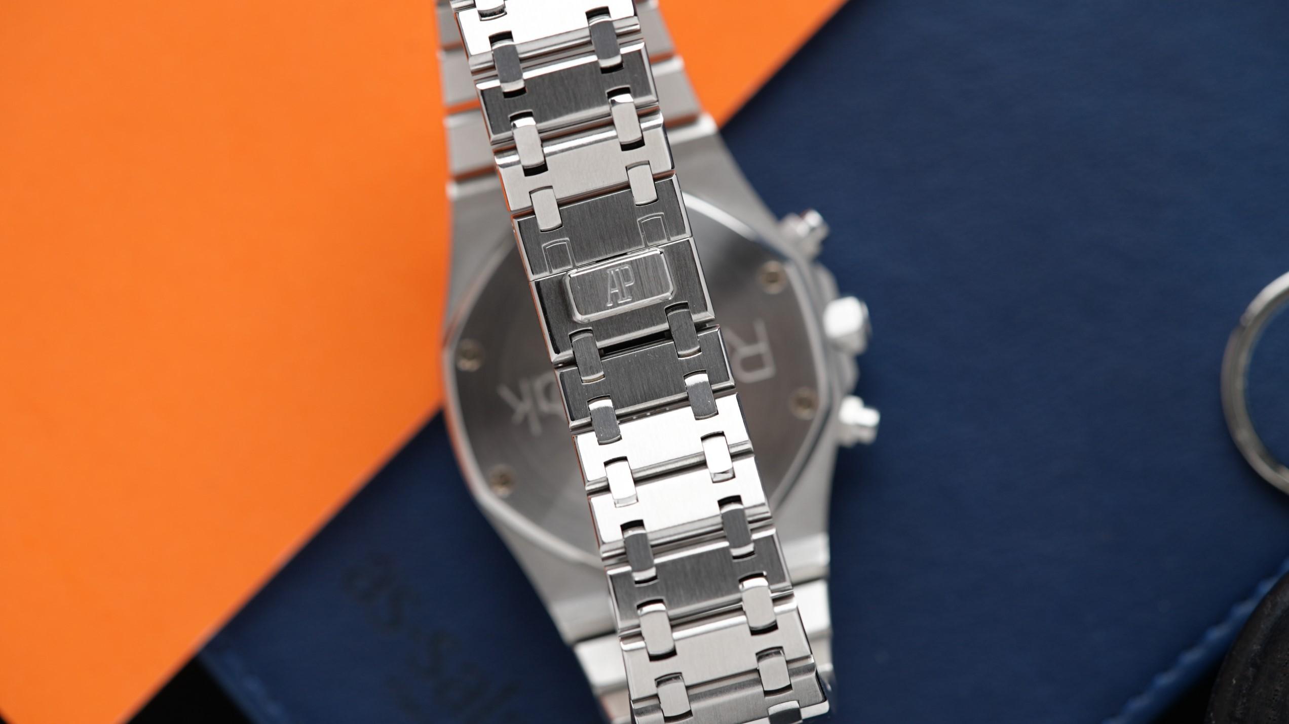The back side, bracelet, and clasp of the Audemars Piguet Royal Oak Chronograph Jumbo 39MM shown under white light with orange and blue background props.