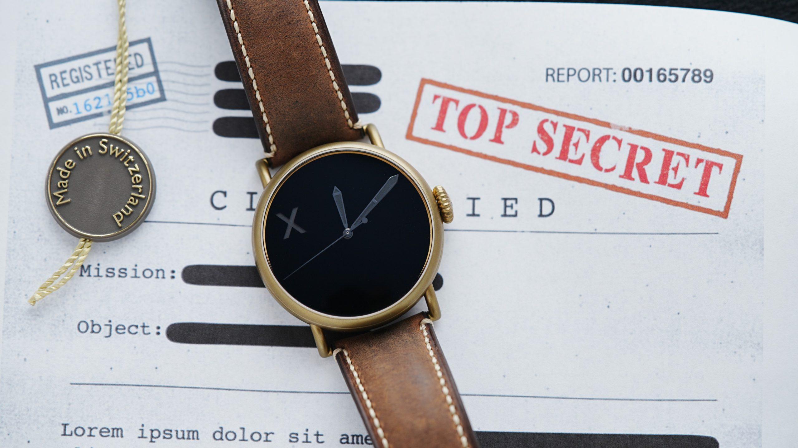 Angled shot of the H.Moser & Cie. Confidential Project X Concept Vanta Black in front of TOP SECRECT DOCUMENT.