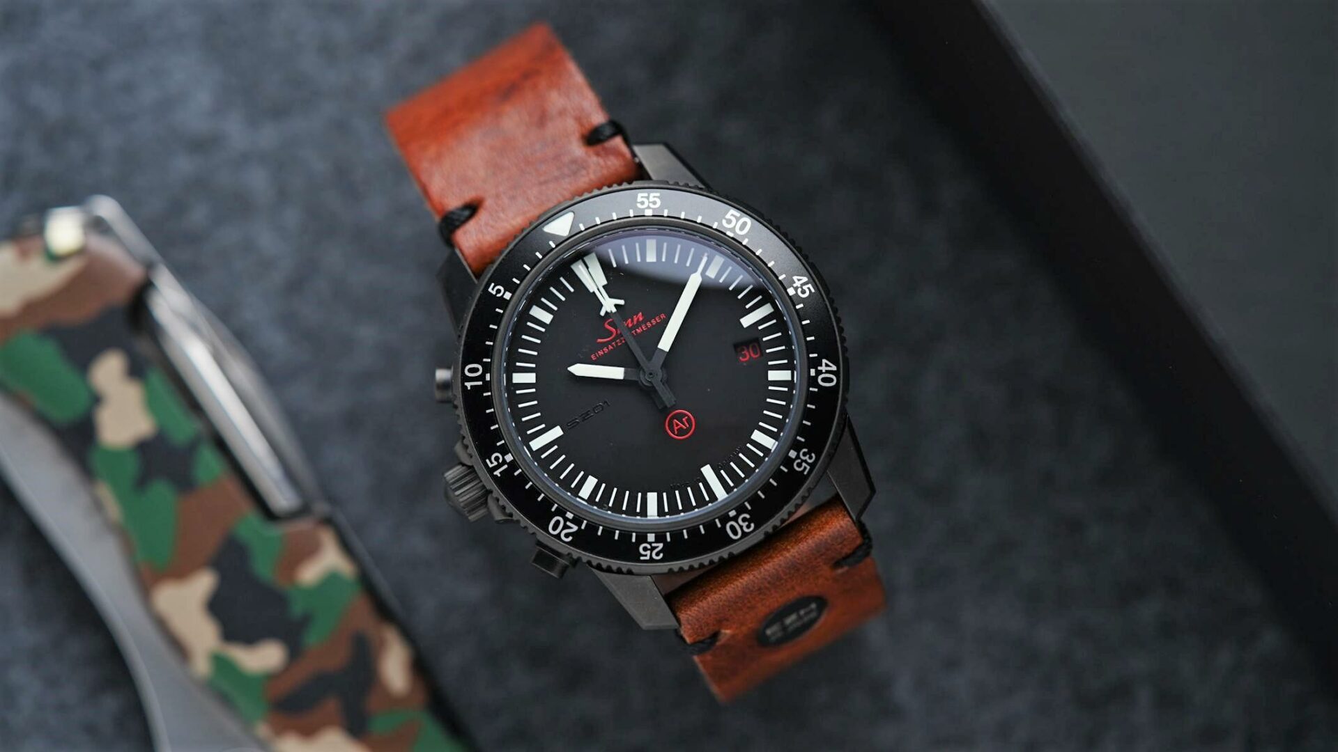 Sinn EZM 1.1S Limited Edition 500 with army knife in background closeup shot.