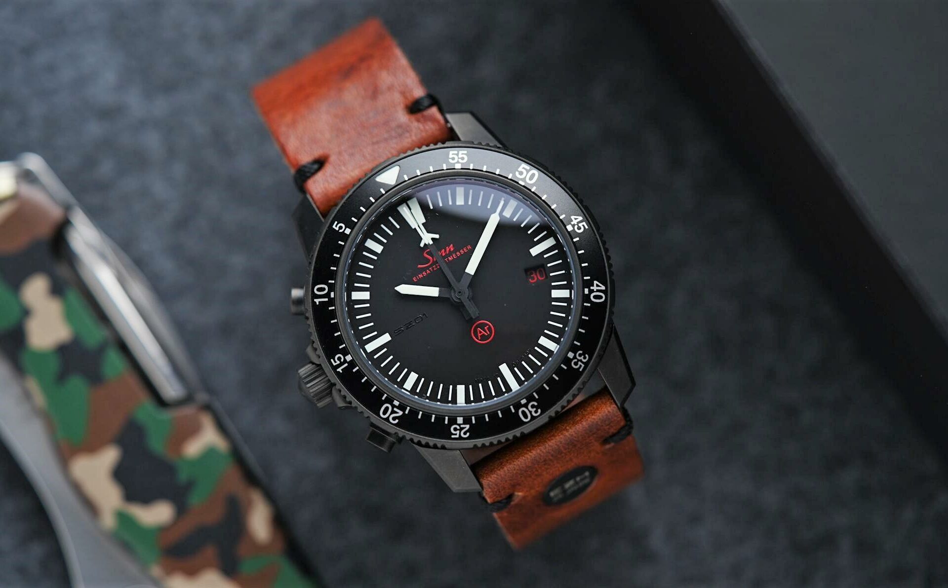 Sinn EZM 1.1S Limited Edition 500 with army knife in background closeup shot.