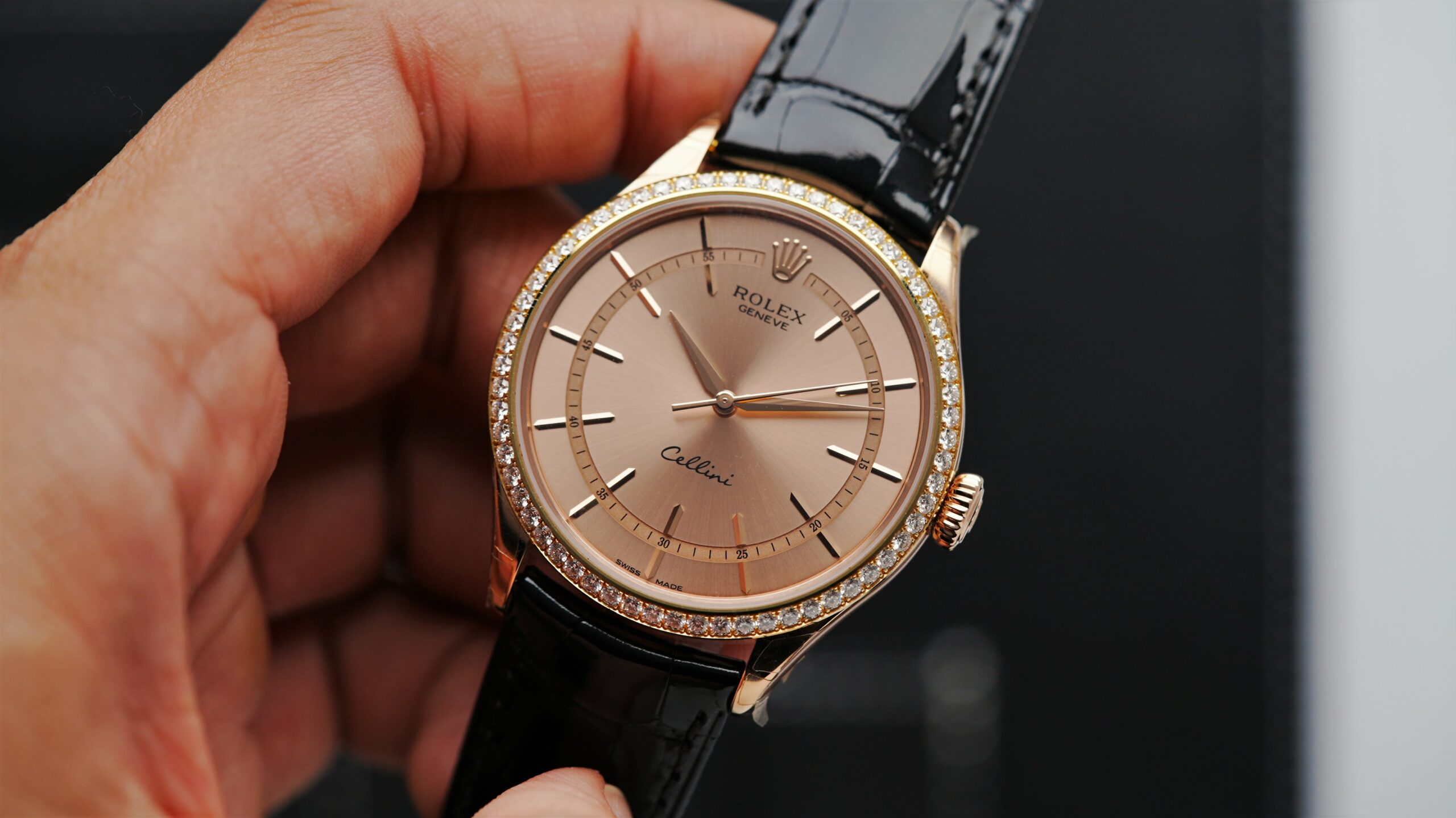 Rolex Cellini Time Salmon Rose Gold watch being held in hand.