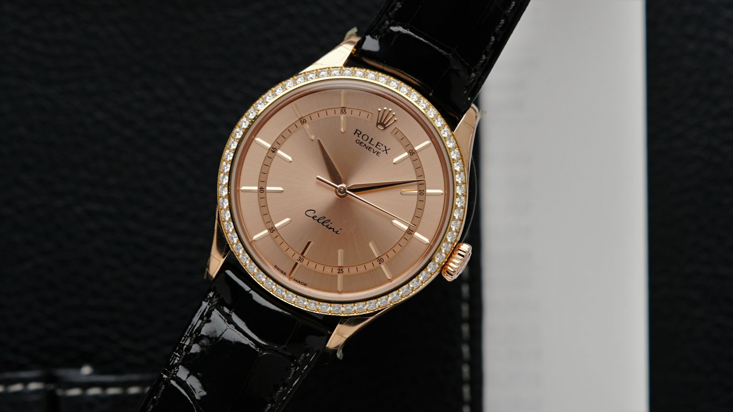 Rolex Cellini Time Salmon Rose Gold watch pictured on an angle under white light.