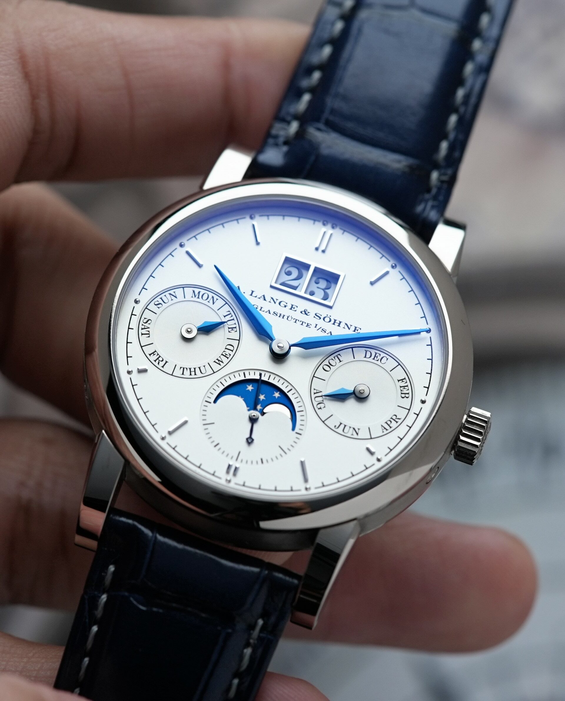 A. Lange & Söhne Saxonia Annual Calendar watch being held in hand.