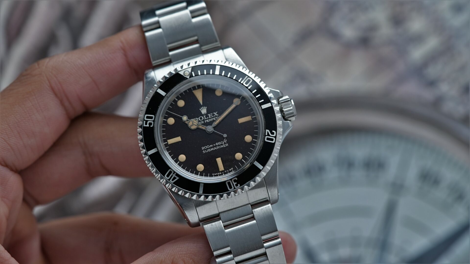 Rolex Submariner 5513 Bart Simpson Tropical Dial Original Patina Unpolished watch being displayed in hand.