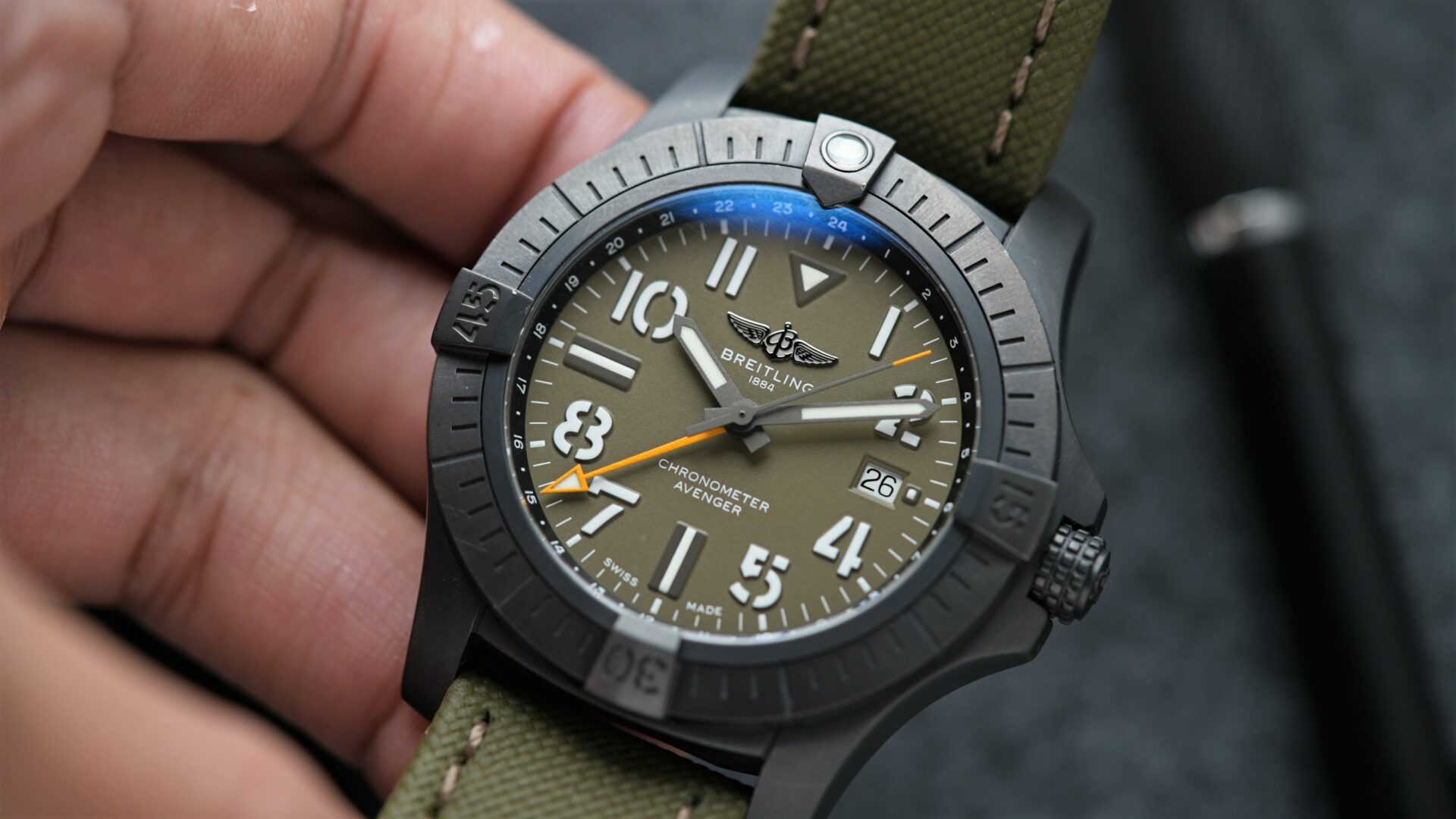 Breitling Avenger Automatic Gmt 45 Night Mission Limited V323952A1L1X1 wristwatch being held in hand.