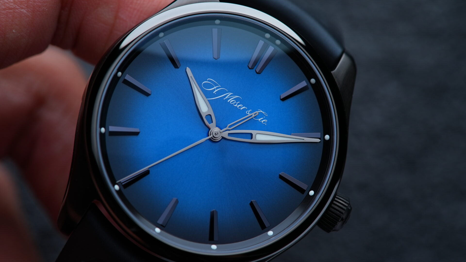 H.Moser & Cie. Pioneer Centre Seconds Funky Blue Fumé Black watch being held in hand.