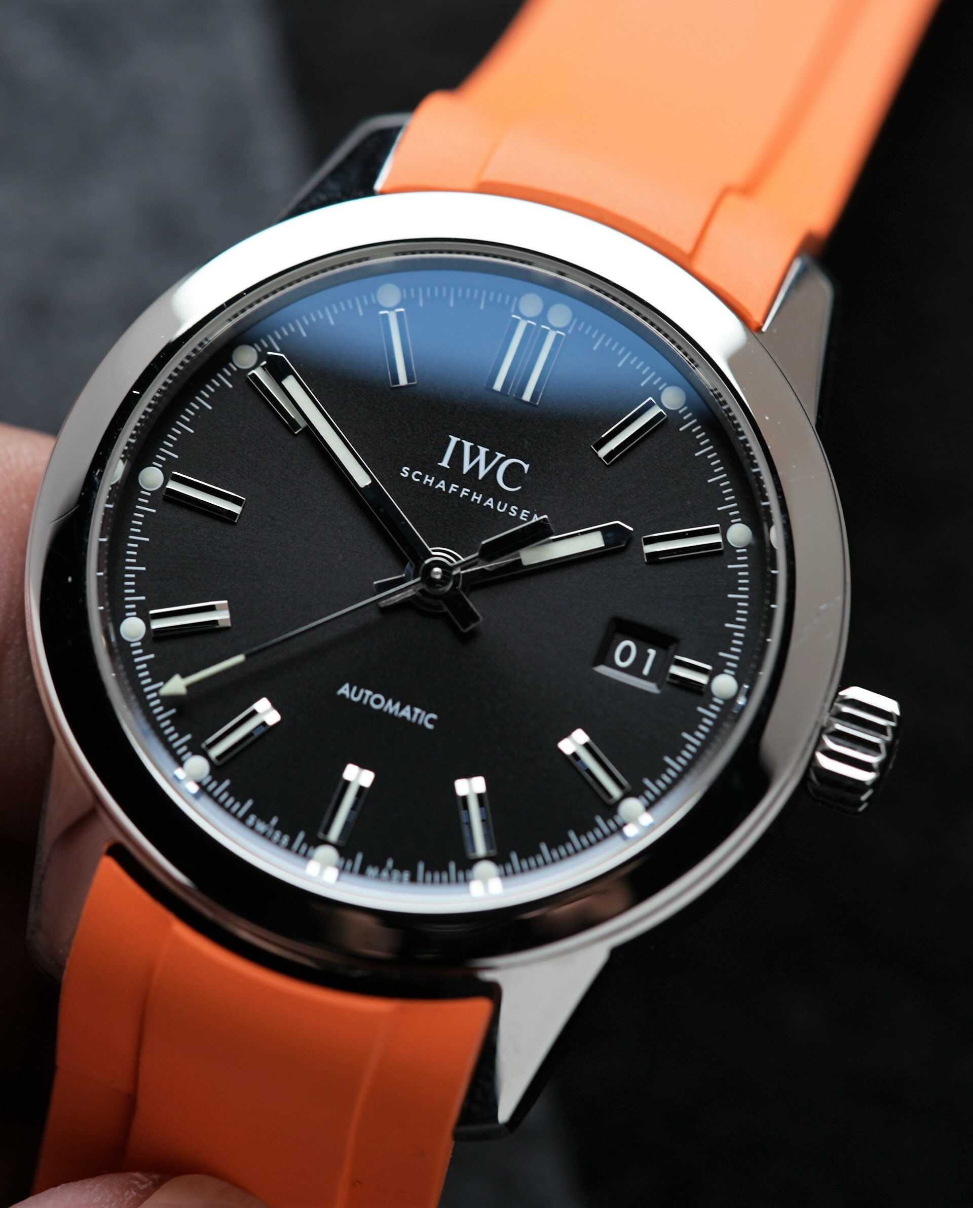 IWC Ingenieur Automatic 40MM 2021 On Bracelet & Extra Orange Rubber watch IW357002 being held in hand.