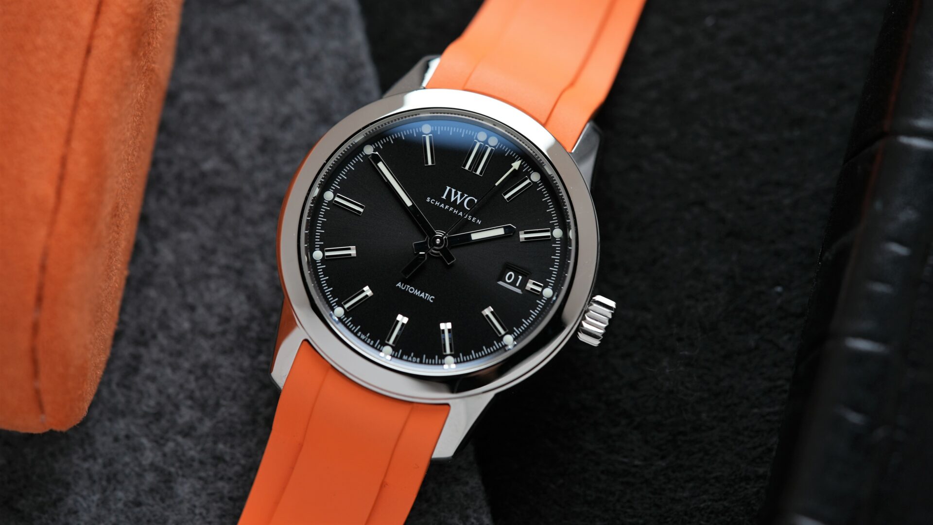 IWC Ingenieur Automatic 40MM 2021 On Bracelet & Extra Orange Rubber watch IW357002 displayed beside orange cushion.