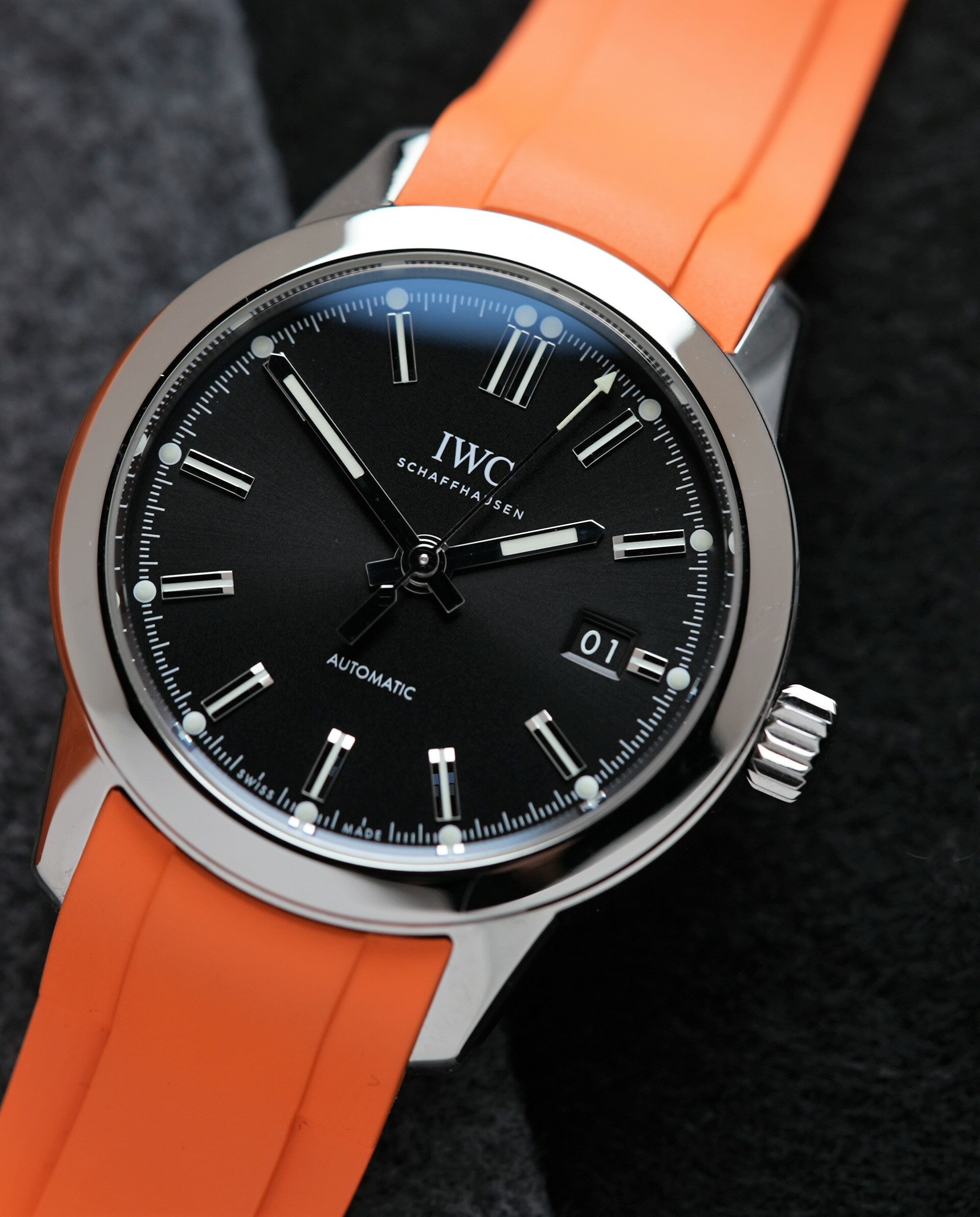IWC Ingenieur Automatic 40MM 2021 On Bracelet & Extra Orange Rubber watch IW357002 displayed beside orange cushion.