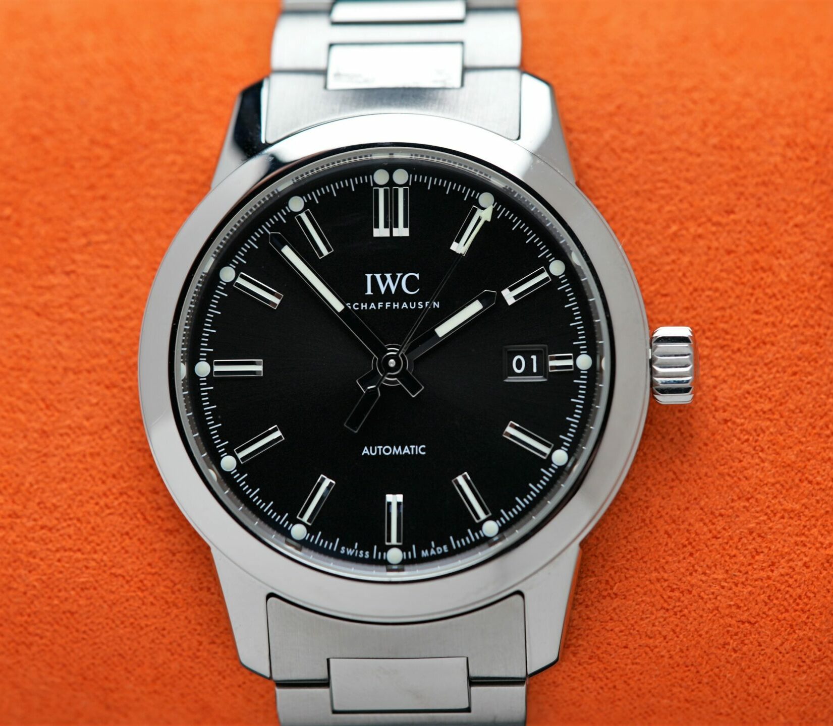 IWC Ingenieur Automatic 40MM 2021 On Bracelet & Extra Orange Rubber watch IW357002 featured under white light on orange cushion.