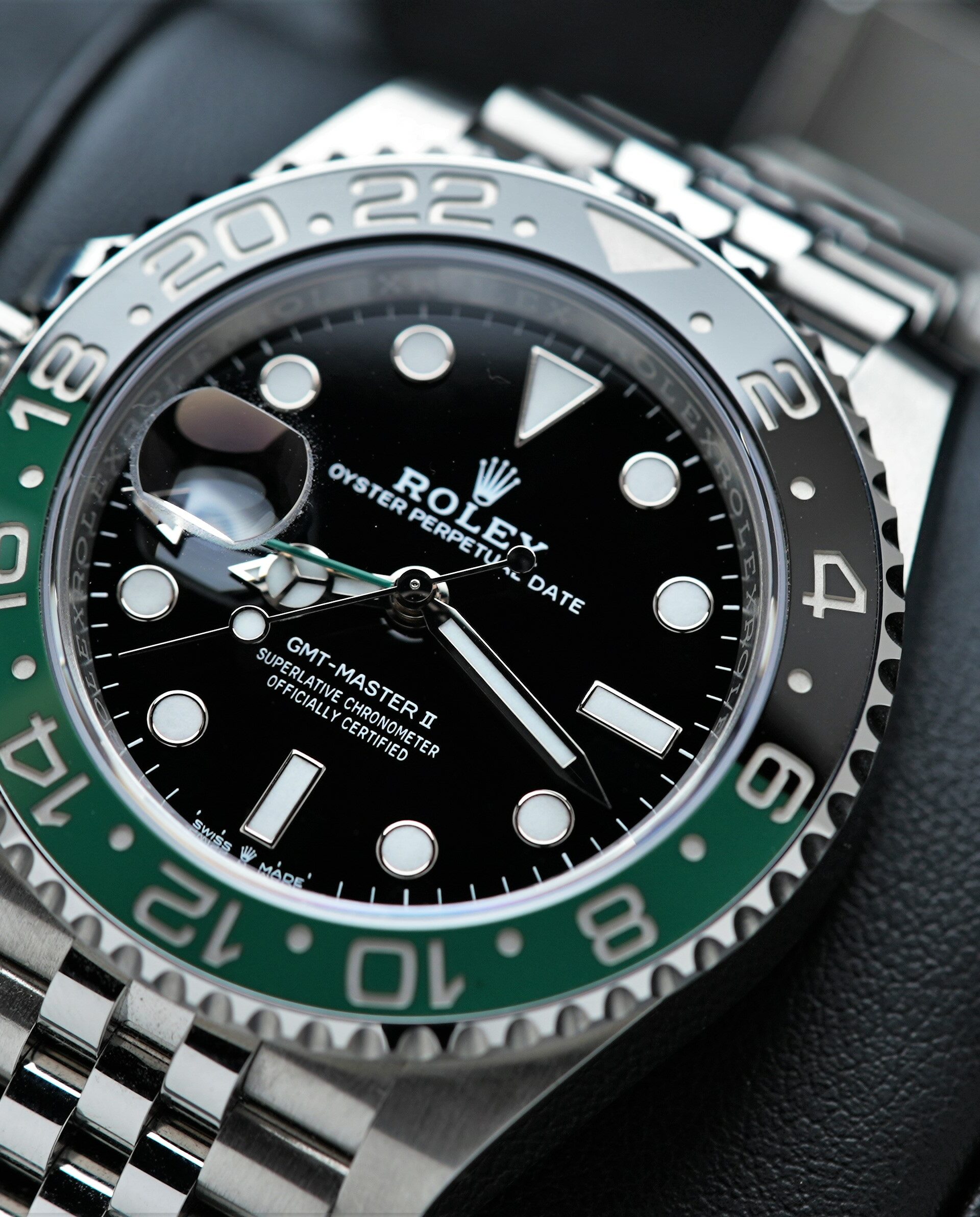 Rolex GMT-Master II 126720VTNR wristwatch on a black cushion under white light.